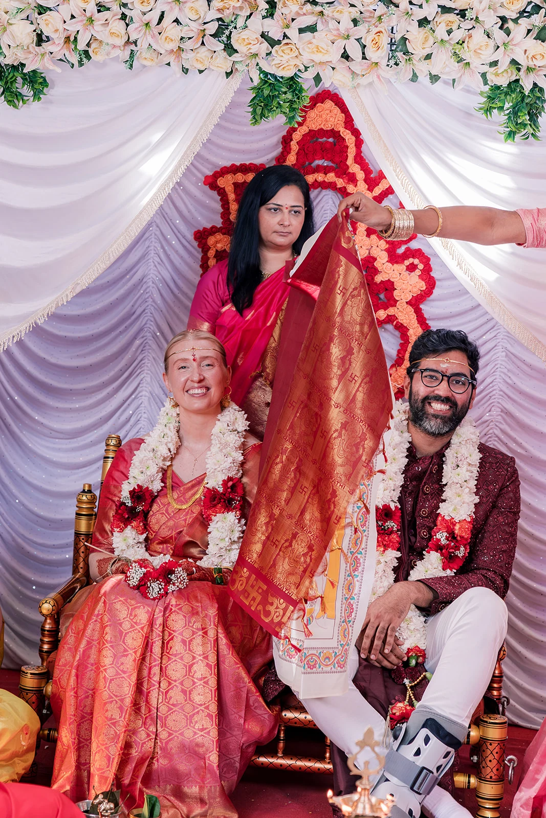 A wedding ceremony with red and gold traditional attire