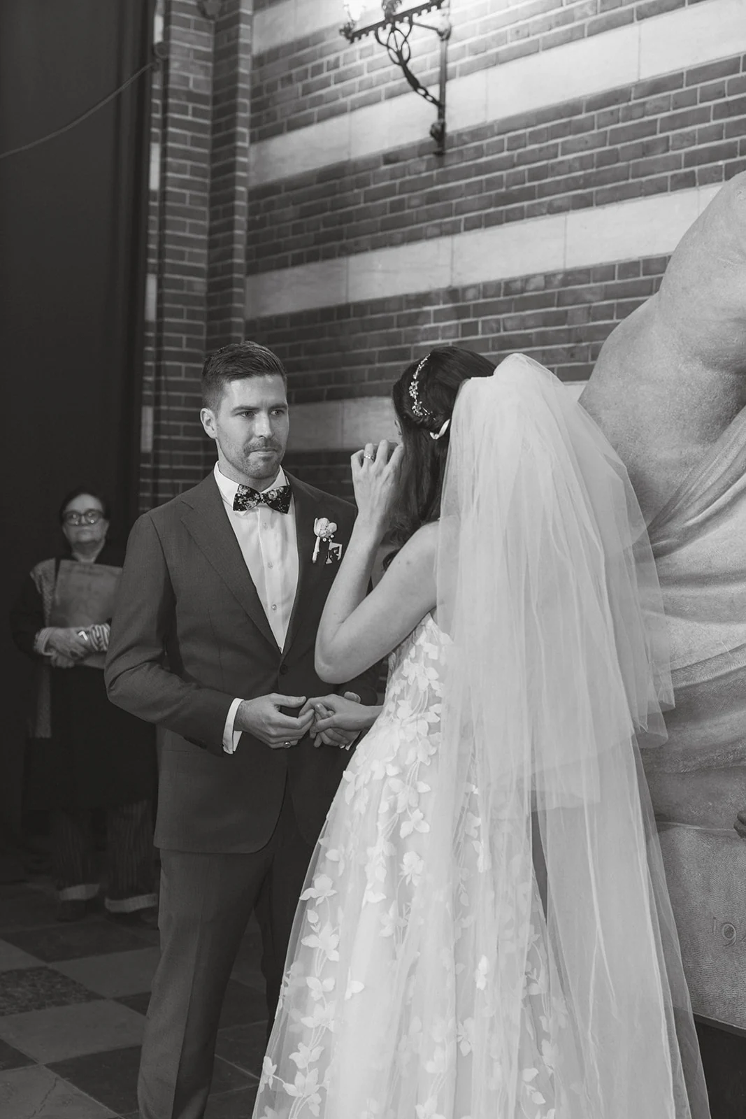 A couple exchanging a glance inside their wedding venue, in black and white