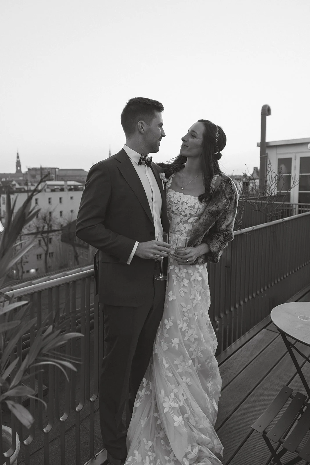 A wedding couple together on a rooftop, in black and white